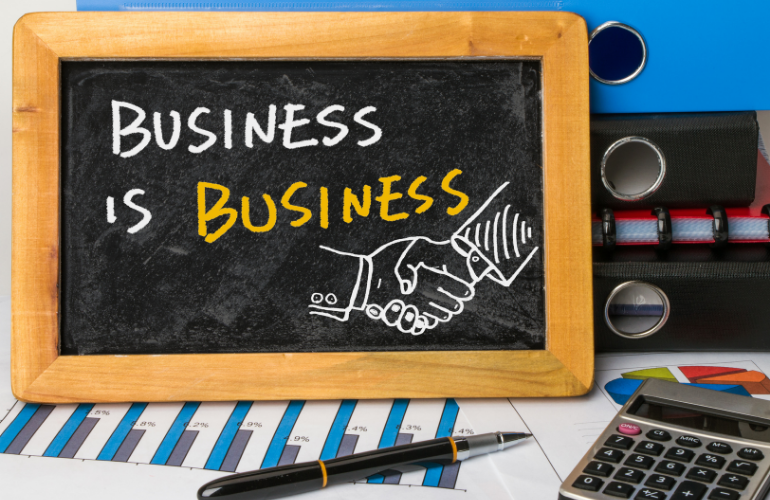 A work desk with blackboard written business is business on it