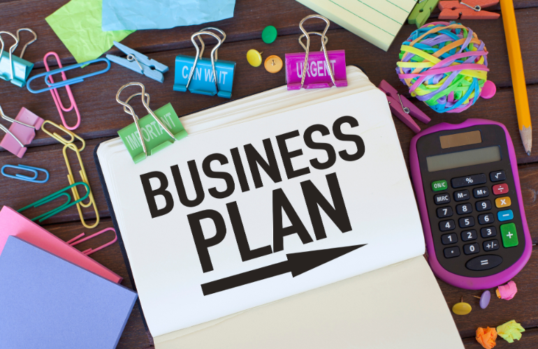 Business plan text written in the notebook on the table