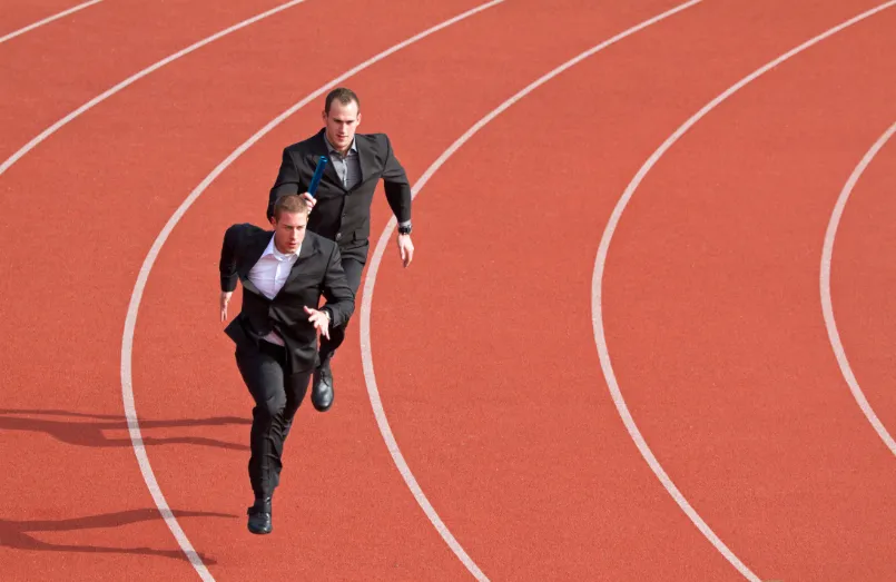 Two businessmen running on race track
