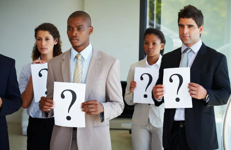 Businessmen and women holding question marks in hands